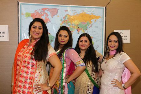 Rutu Patel AS 17, Vibha Babhar AS 17, Mansi Shah AS 17, and Pooja Palaksha AS 17 pose in front of the world map highlighting student’s home countries.