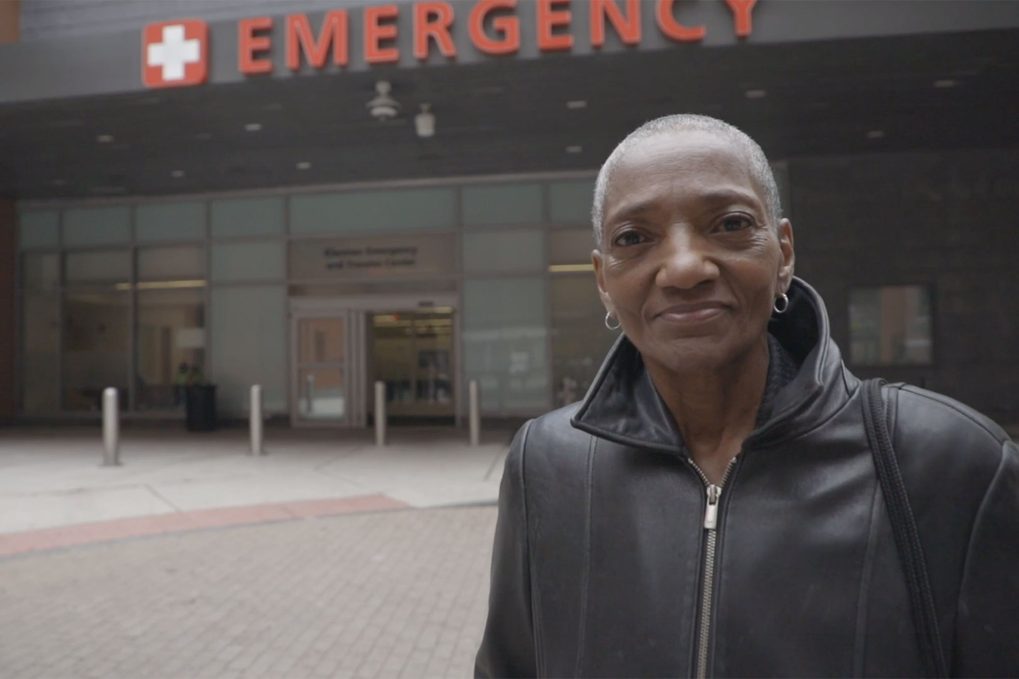 Thea James standing in front of the Emergency entrance of a hospital