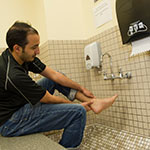 Man using a foot bath on campus to clean his feet