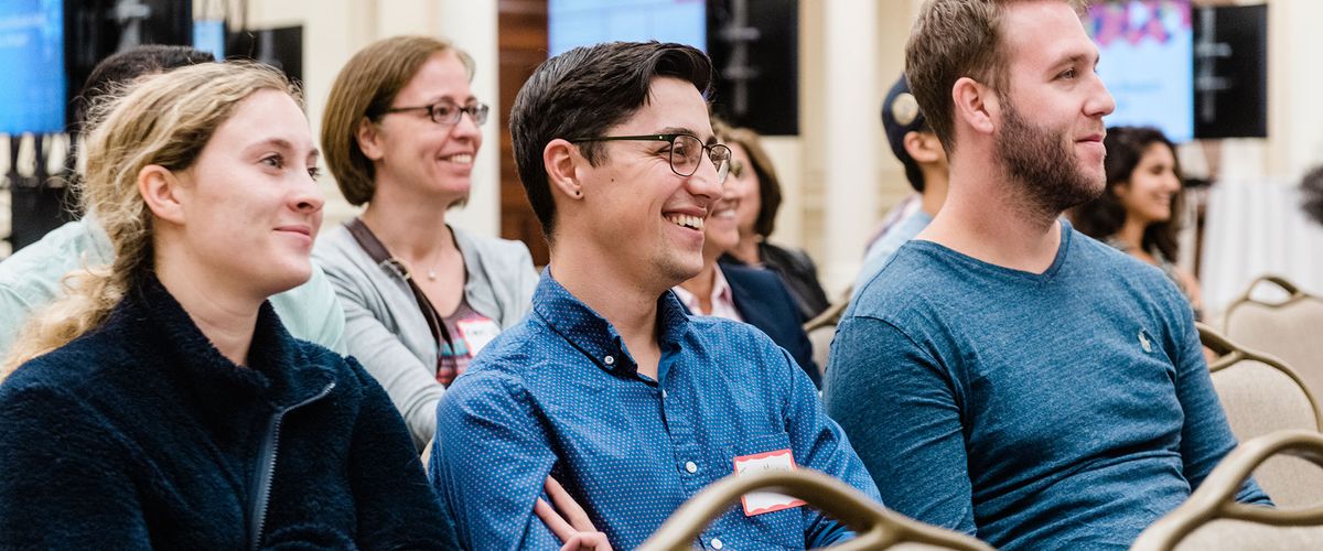 Three students sitting in audience of a Diversity & Inclusion event
