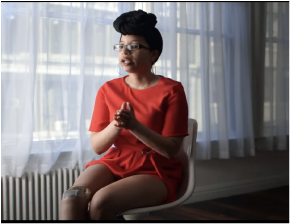 Portrait of Keri Gray on a chair wearing a colorful dress
