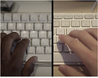 Two people typing on keyboards one of a white hand and the other of a black hand
