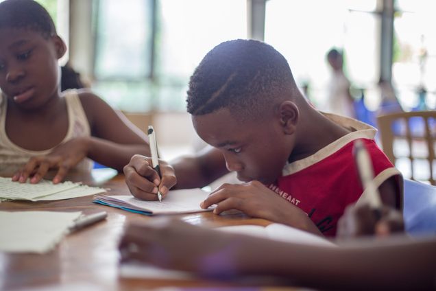 Black students at desks writing
