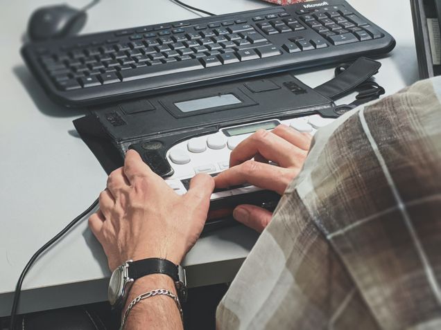 Person using accessibility device next to keyboard