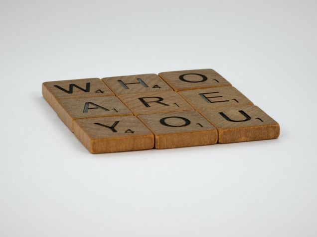 Scrabble letters coasters stating "Who Are You"