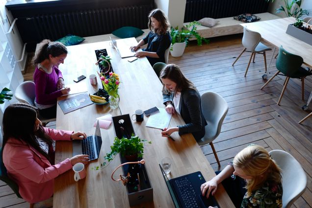 Image of five women working in an office setting