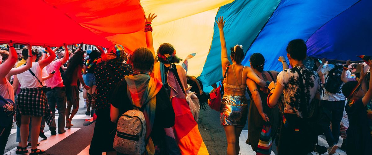 People underneath a pride flag