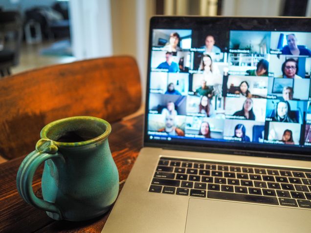 Image of a laptop on a zoom call with mug next to it