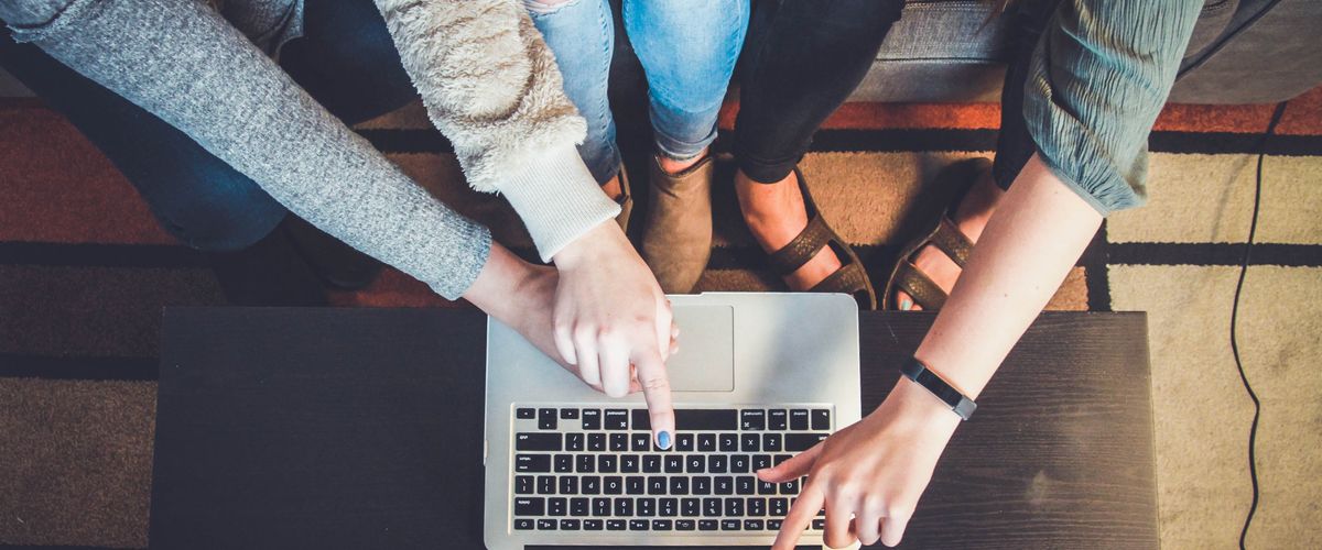 People pointing at a laptop screen
