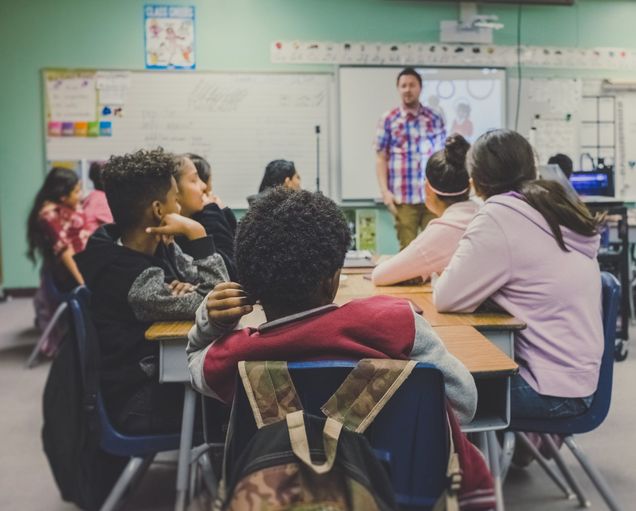 A group of students listening to their instructor in a classroom