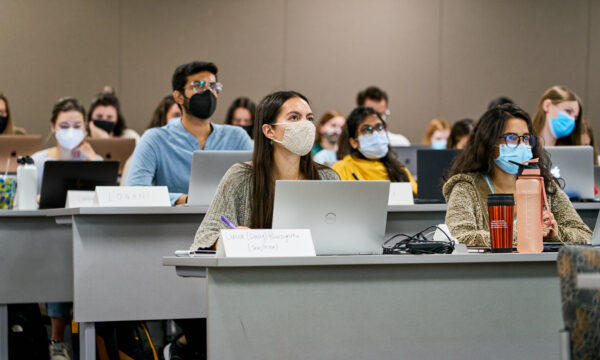 Students in class in masks with computers