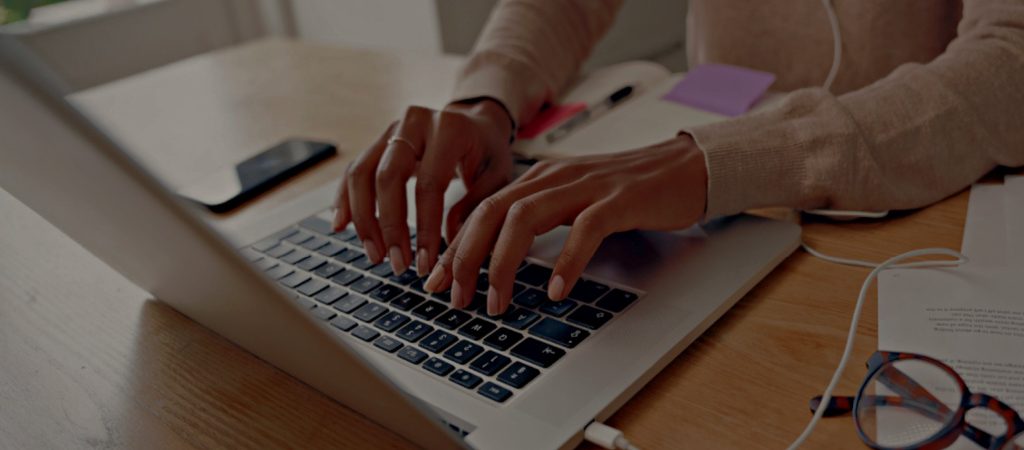 Image of a women's hands typing on a laptop keyboard
