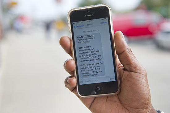 Hand holding a mobile phone showing emergency notification