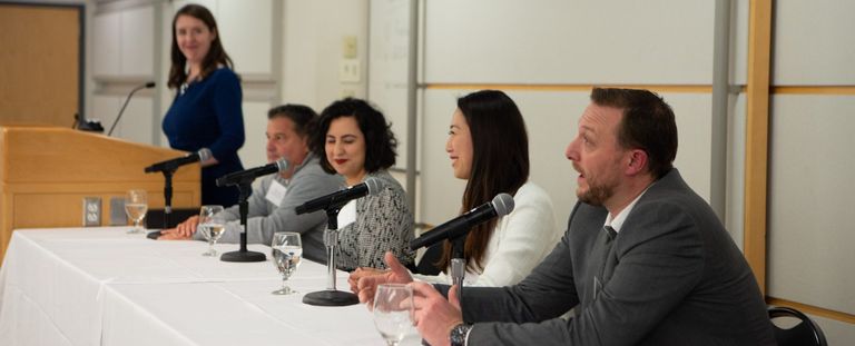 Alumni panelists smiling at networking event