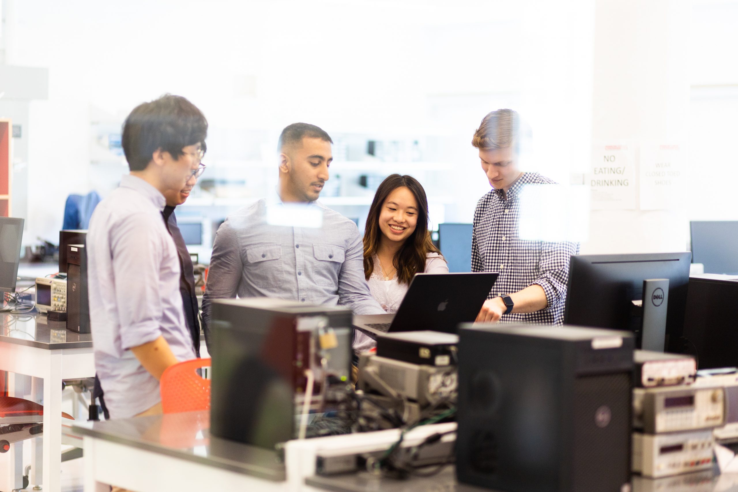 A group of students engaging with one another in a lab setting