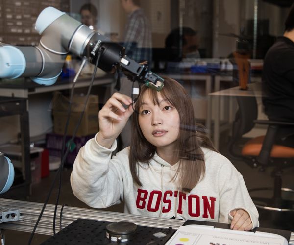 student working on a robotic arm