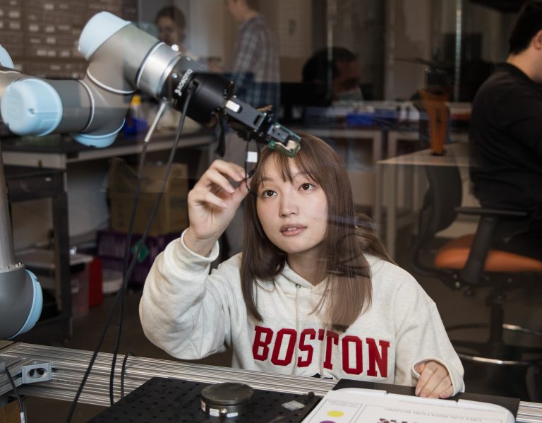 student working on a robotic arm