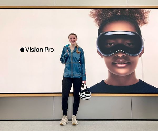 Brynna Freitag with a poster of th eApple Vision Pro