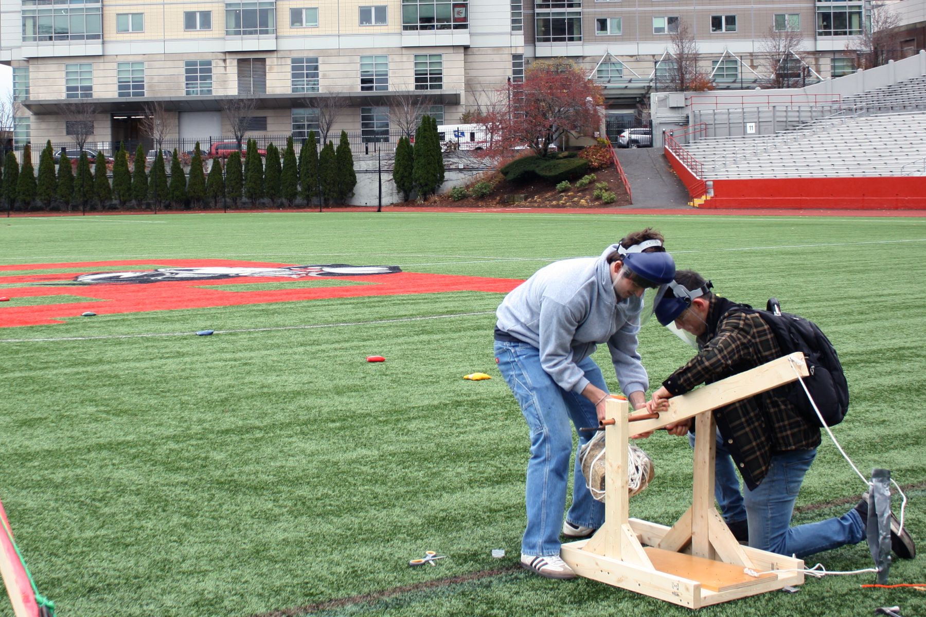 wide shot of 2 students getting their catapult ready to launch