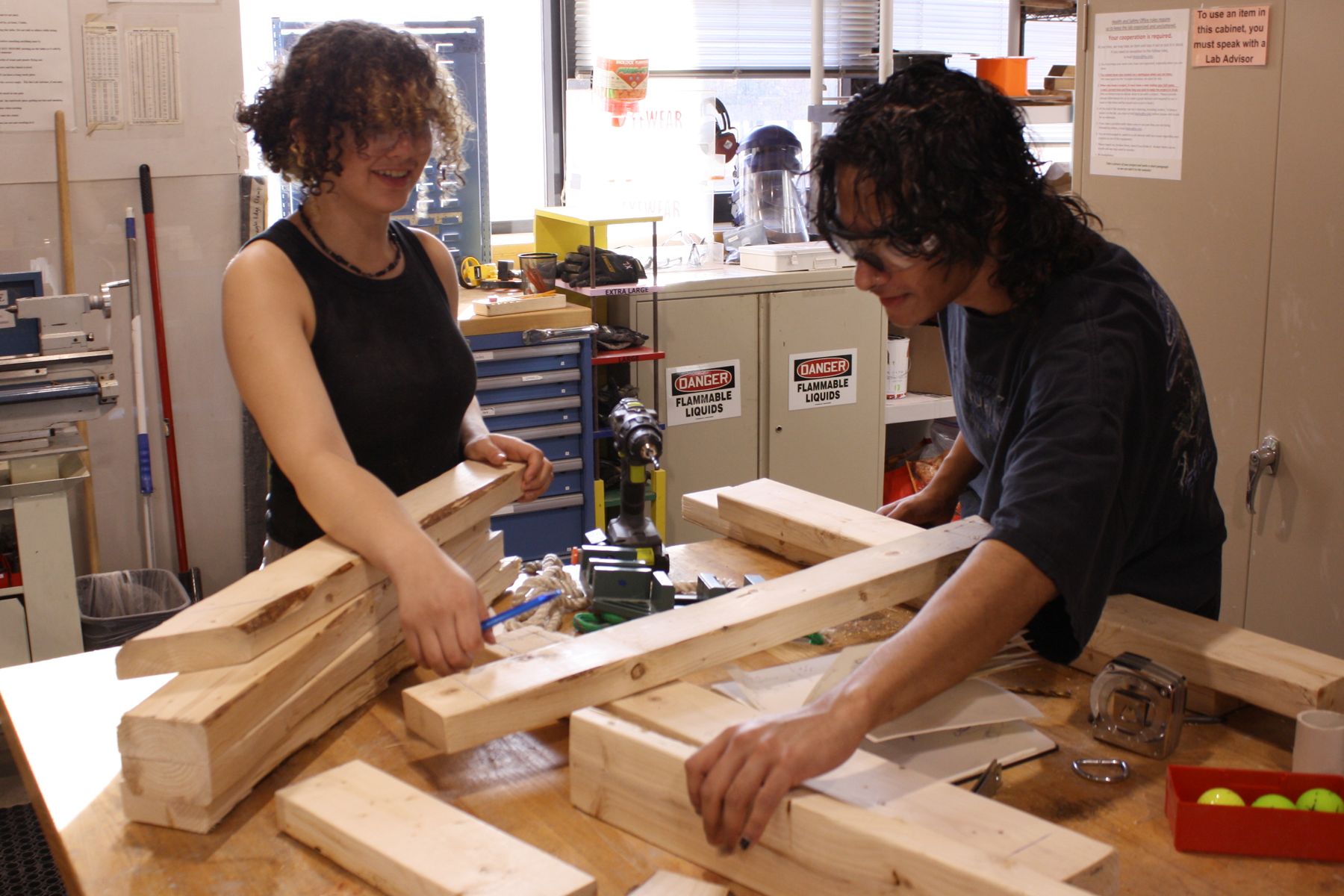 2 students moving around 2x4 boards while building their catapult
