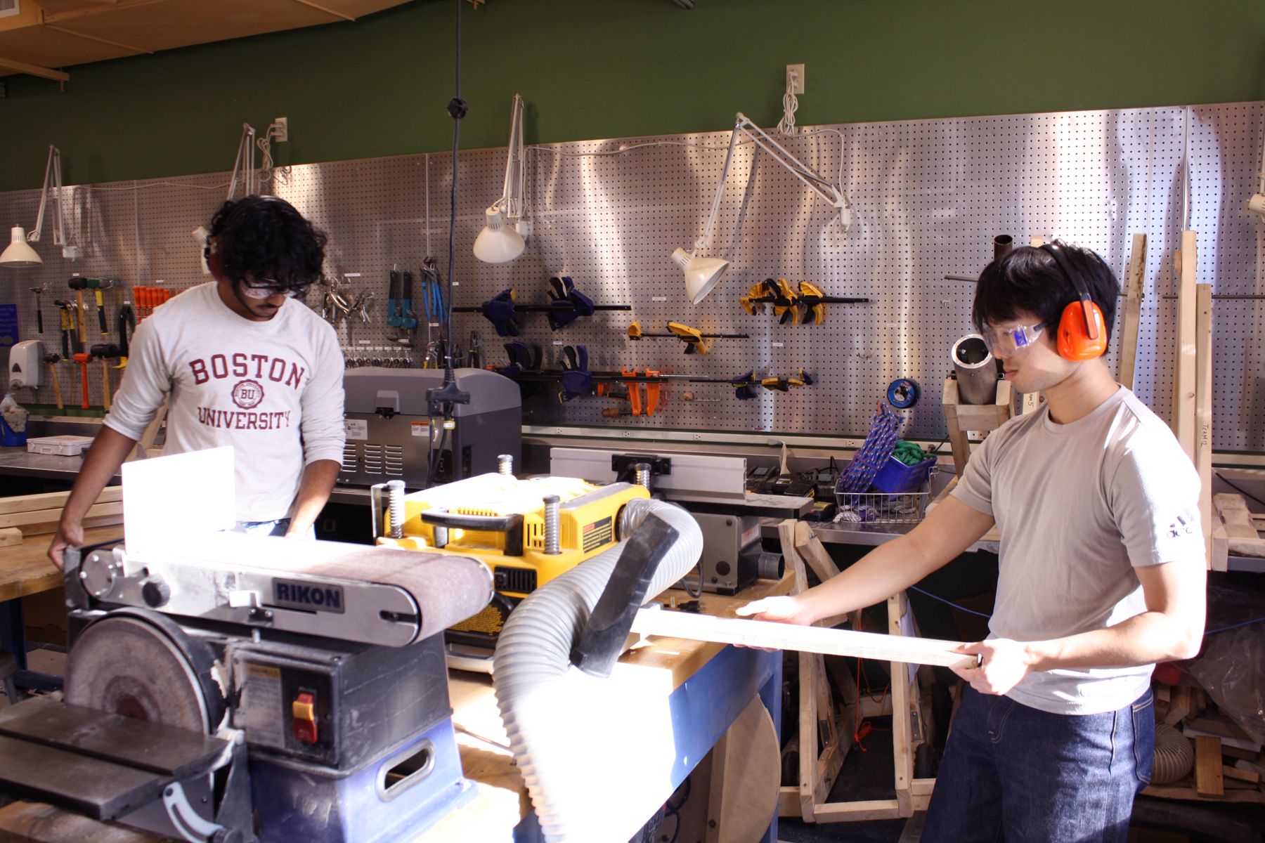 2 students working together to use the planer on their board