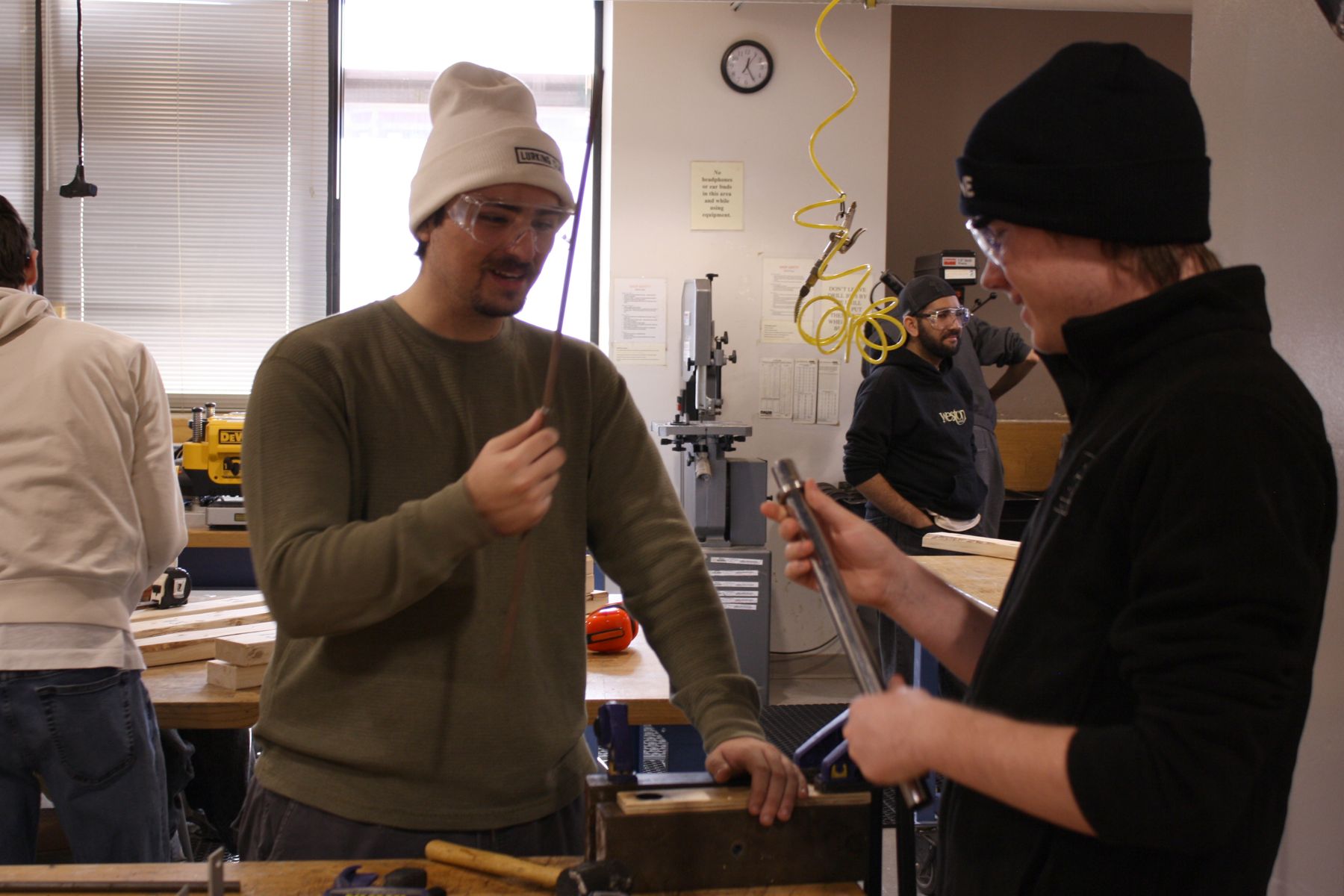 2 students each holding a steel rod discussing which one to use in their project