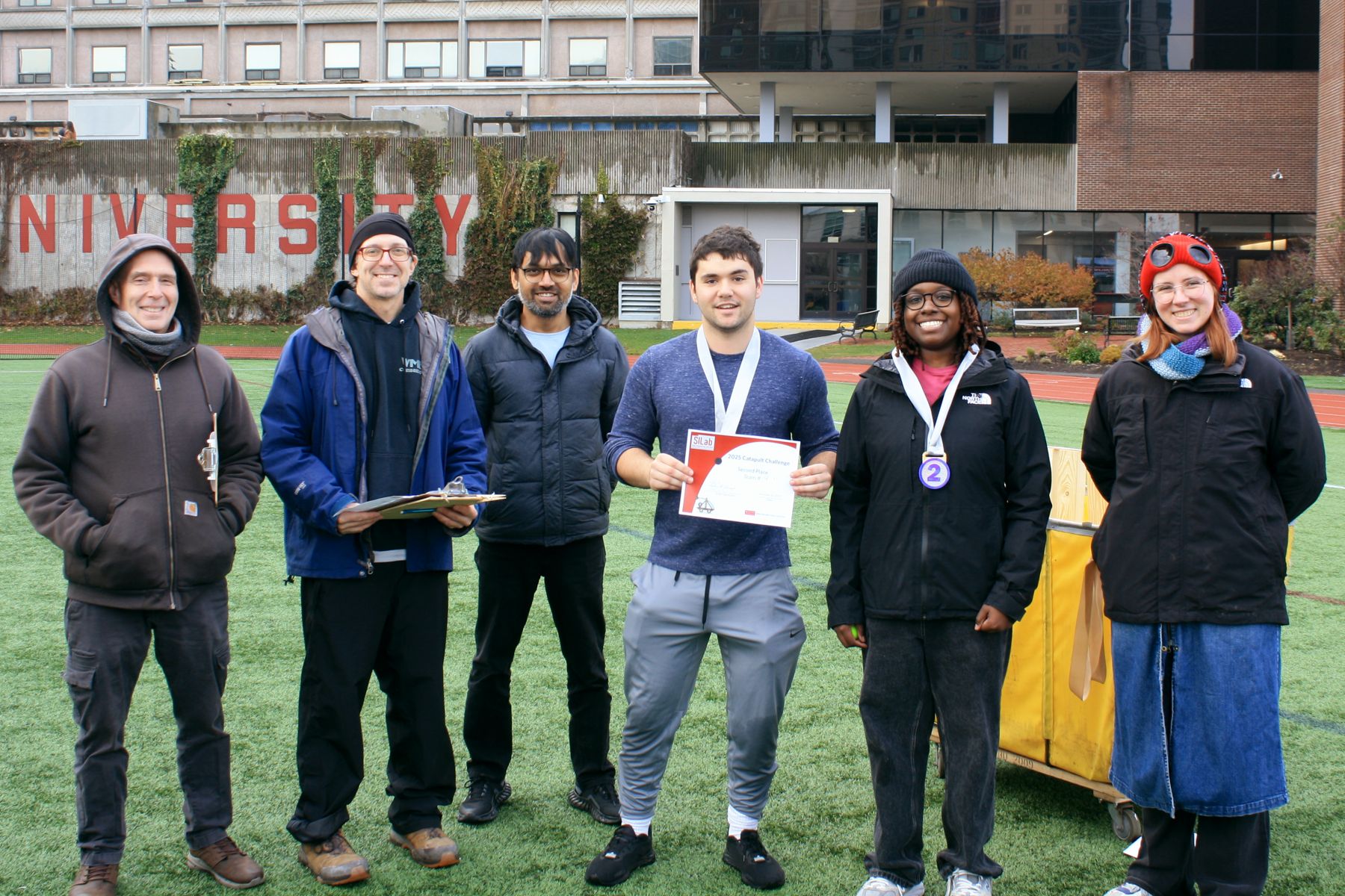 the 3 judges, 2 students from the 2nd place team, and the silab manager all in a line