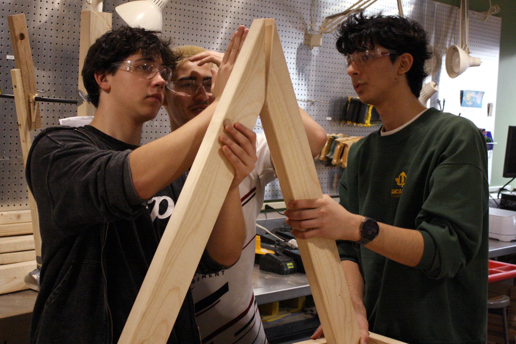 3 members of the team holding up their angled supports to see how they need to adjust them