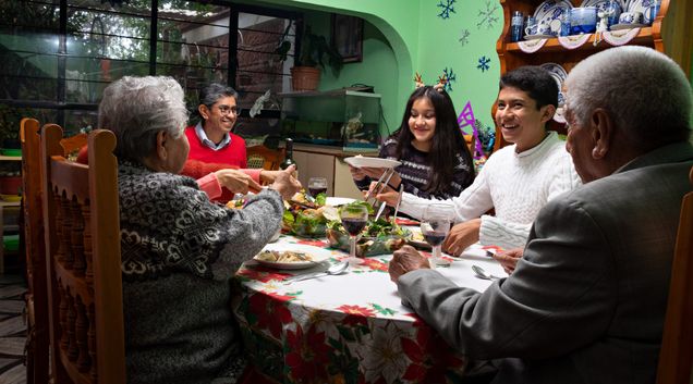 Latinx family sitting around dinner table.