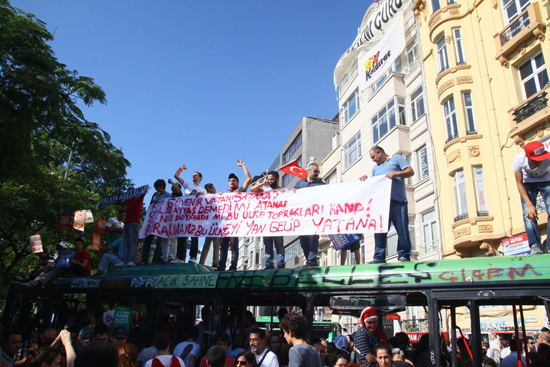 Protestors on bus wreckage, Taksim Square, Gezi Park, Istanbul, Turkey Antigovernment protests in Taksim Square, Gezi Park, Instanbul, Turkey, June 2013, Occupy Gezi