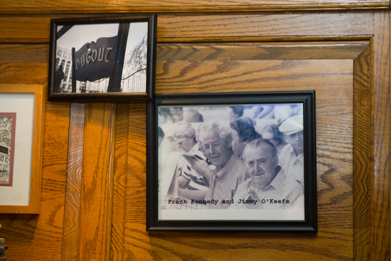 A photo of Frank Kennedy and Jimmy O’Keefe hangs on the wall behind the Dugout Cafe bar. A bartender at the Dugout for decades, Kennedy could point out where the Brinks robbers sat in the bar to plan their heist. Photo by Cydney Scott
