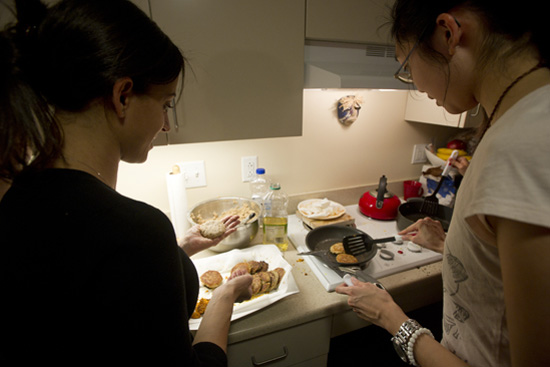 Exchange student Mariana Souza (left) and Queenie Yeung (SAR’15,’16) fry Nana’s latkes in Jacob’s kitchen.