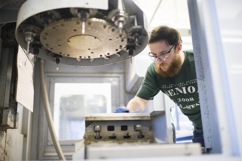 Cleaning a computer numerical control machine at Boston University Engineering Product Innovation Center
