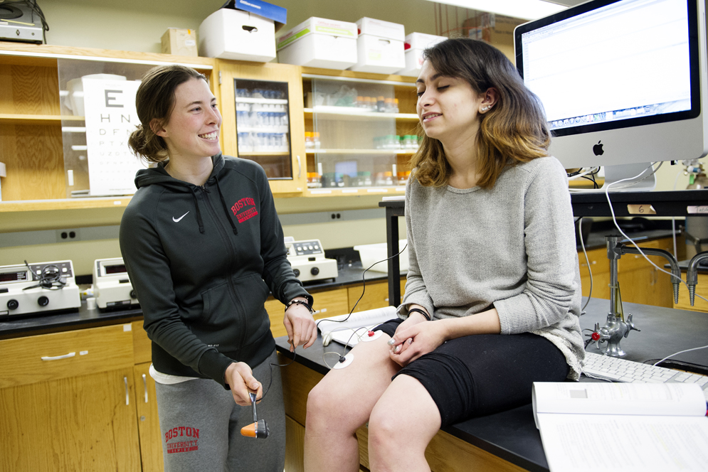 Dominique Baker (SGT '16) and Crystal Michaelides (CAS '15)  learn about reflexes and sense of touch in a Systems Physiology lab. Photo By Jackie Ricciardi