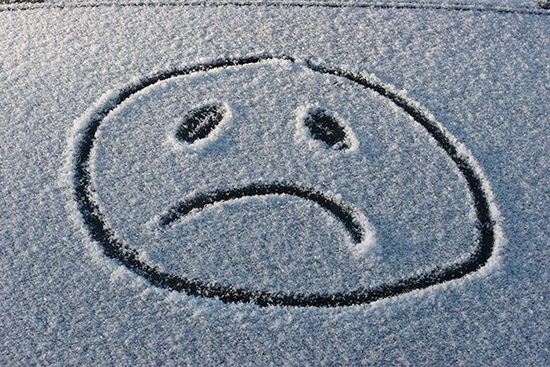 sad face in snow symbolizing winter depression or winter blues