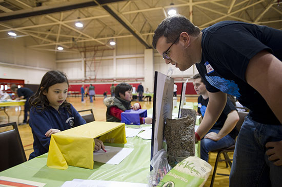 At last year’s B.R.A.I.N Day, Anan Desimone, 9, of Brookline, tries her hand at mirror drawing while Alex Barber (CAS’14) looks on. BU is sponsoring B.R.A.I.N Day again this Sunday. Photo by Cydney Scott.