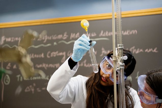 Krishna Singh (CAS 18) checks the liquid in a test tube as her lab partner