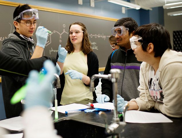 Kelly Demeo (CAS 16) works with O'Bryant School of Mathematics & Science students during a glow stick lab on Friday, May 1, 2015. Photo by Jackie Ricciardi