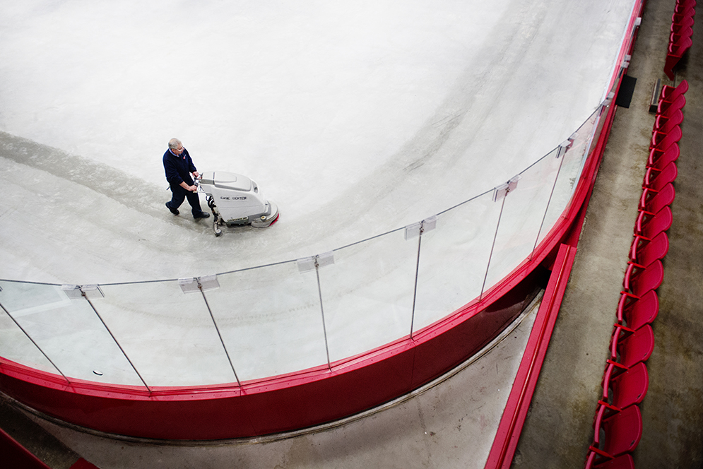 Facilities worker, Luis Barbosa cleans the concrete on the hockey rink at the Walter Brown Arena