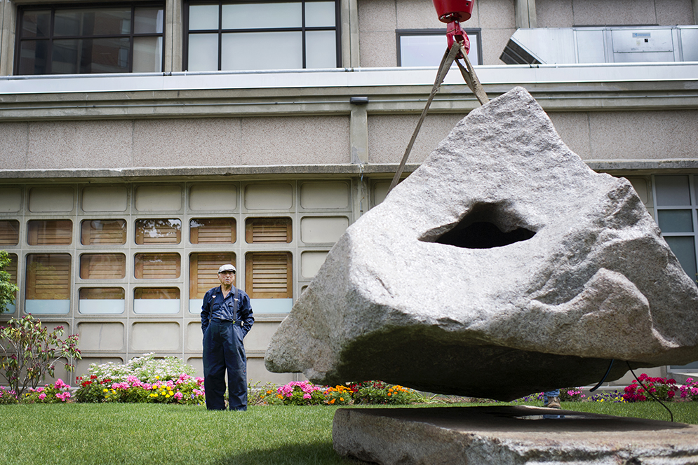 Edward Monti of Quincy watches as a crane moves his fountain to face the correct direction on West Campus