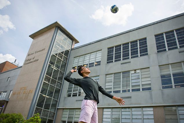 Steven Xie (CAS'17) playing volleyball on the COM lawn