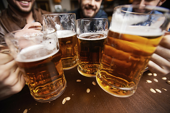 Four men toasting with beer