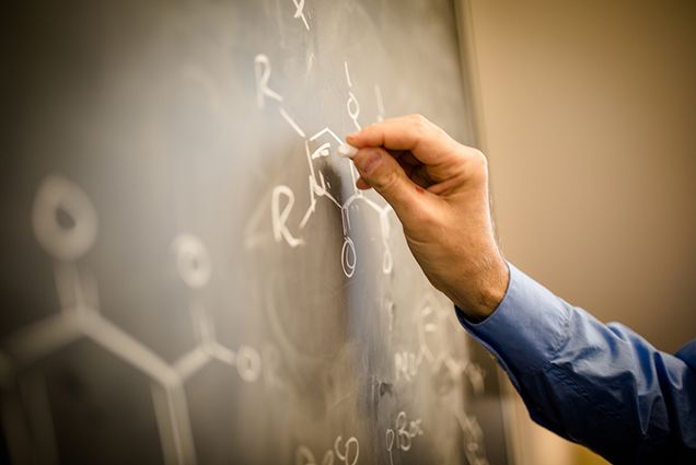 Drawing a molecule on a chalkboard at the Boston University Center for Molecular Discovery