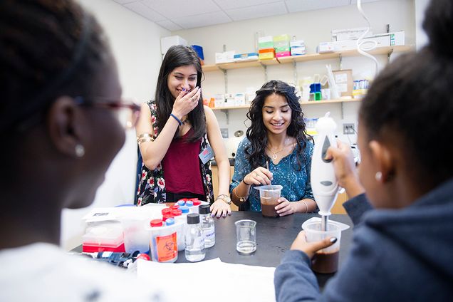 Mehar Maju (CAS 17) and high school student, Diana Callejas laugh at the sound of chocolate in a blender during a nanotechnology lab at SED on Wednesday, July 15, 2015. Mehar is an instructor at Upward Bound, a college preparatory program for potential first-generation college and low-income Boston Public High School students.   Photo By Jackie Ricciardi