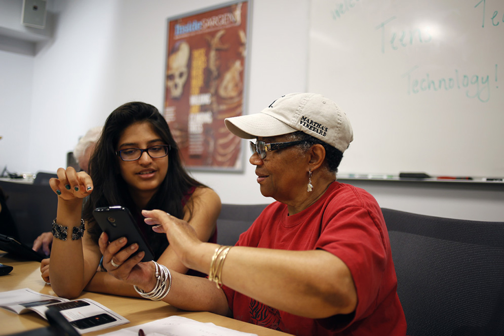Prakalya Chandrasekar (left) teaches Cathy how to use smartphone apps through Teens Teaching Technology, a program in the Department of Speech, Language and Hearing Sciences in Sargent College that provides ongoing rehabilitation to services to aphasia patients.