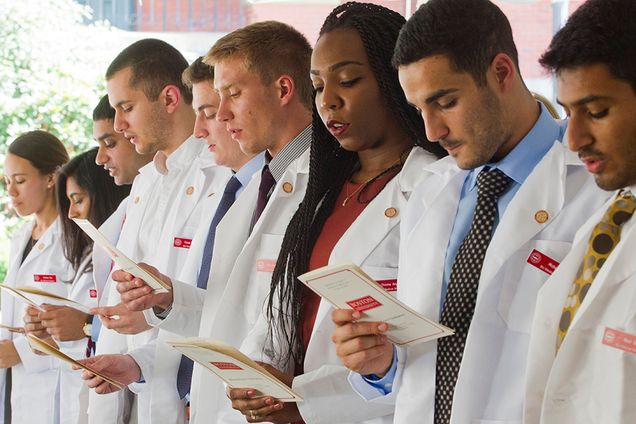 Members of BUSM 2019 recite The Hippocratic Oath at the School’s annual White Coat Ceremony Aug 3, 2015. The group comprises 180 students selected from a pool of 10,929 applicants. Academically, it is one of the most accomplished classes yet; 28 students hold a graduate degree at the Masters level or above, and several have more than one graduate degree. The entering class also is one of the most diverse in BUSM’s history, representing 36 states, 17 countries. As a group, they speak 27 different languages; 148 students speak more than one language.  Photo by Cydney Scott