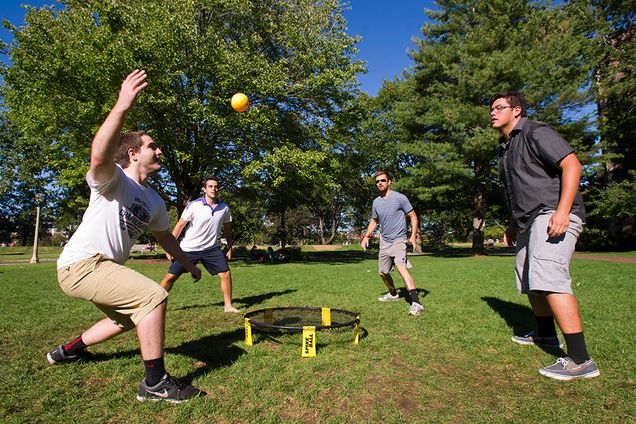 Dylan Farrell (ENG'17) from left, Spencer Hilton (Questrom'16), Dave Roger, chaplain at Marsh Chapel, and Michael Munoz (ENG'16) enjoy the cooler temperatures with a round of Spike Ball on BU Beach 