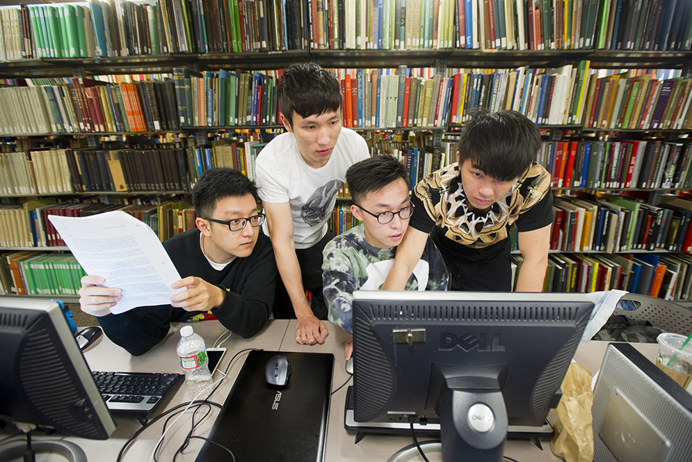 Zhang Jinzhen (Questrom'16), from left, Jiatao Sun (Questrom'16), Ye Wei (Questrom'16), and Shoukui Wang (Questrom'16) work together at Mugar Library September 27, 2015. Photo by Cydney Scott
