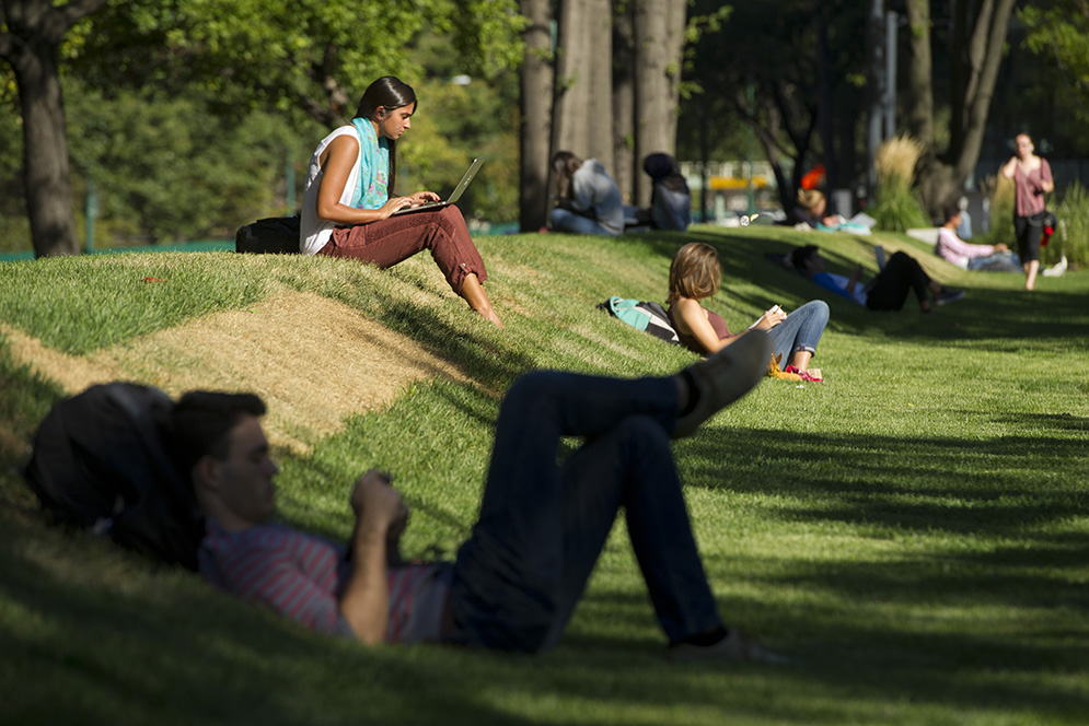 Students, including Catherine Campion (SAR'16), left, take advantage of the sunny skies and renewed grass near BU Beach. Photo by Cydney Scott