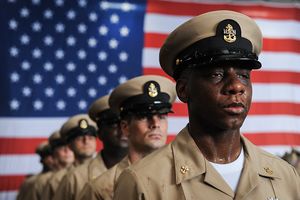 New Chief Damage Controlman Keith Frizell stands at attention after being pinned to chief petty officer during a chief pinning ceremony aboard the aircraft carrier USS Theodore Roosevelt (CVN 71).